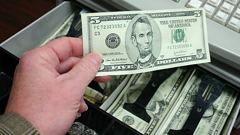 hand holding money over register