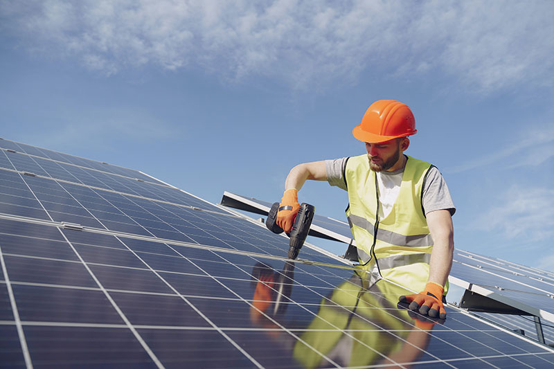 Image of a man working on solar panels.
