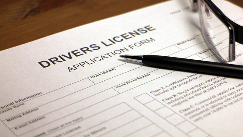 Driver's license application with pen and glasses on a table