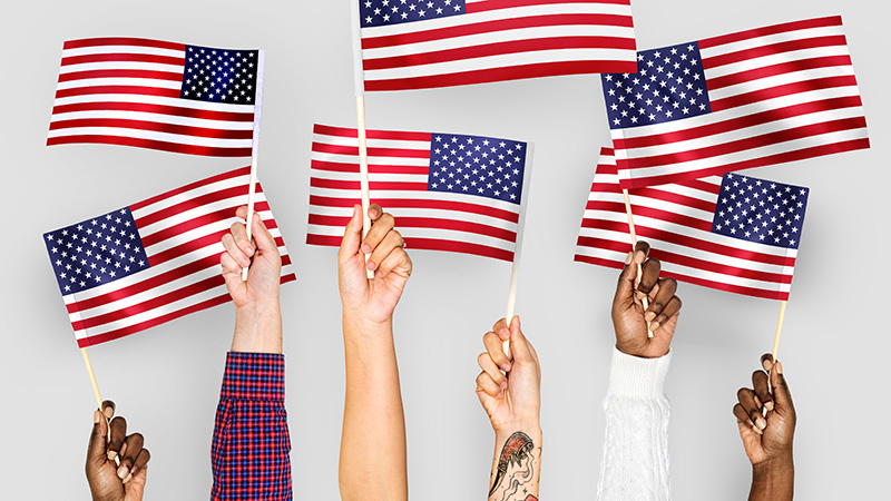 Multiple hands holding American flags