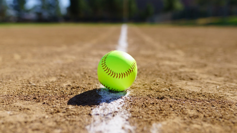 a softball placed on the foul line of a softball field