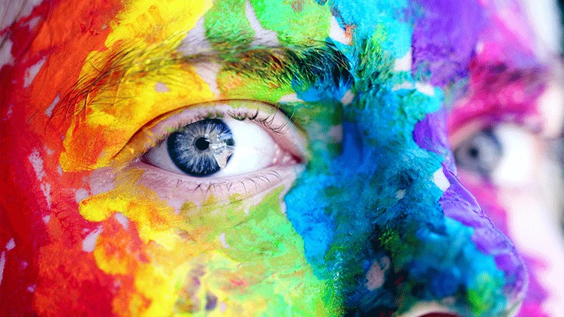 Close up of person with pride colors painted on their face