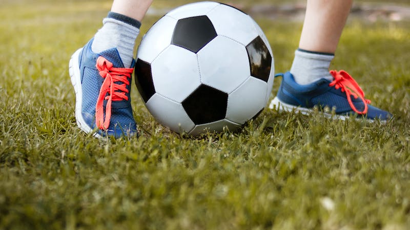 graphic of feet in sneakers playing with soccer ball